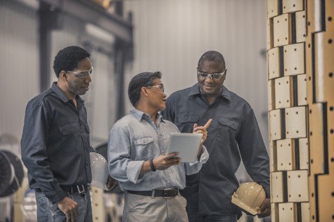 Workers looking at equipment in factory