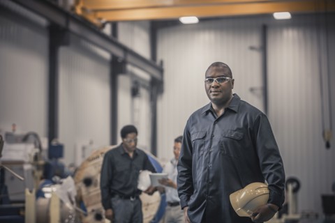 African American worker standing in factory