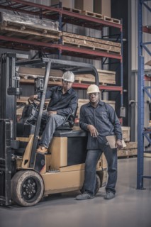 African American workers with forklift in factory