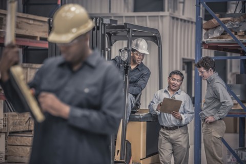 Workers talking together in factory