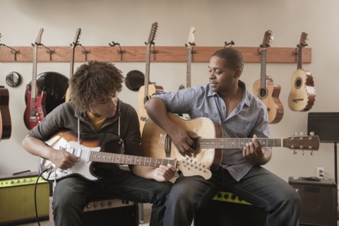 Father and son playing guitars together
