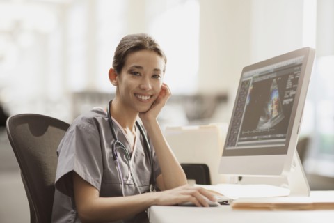 Mixed race nurse using computer