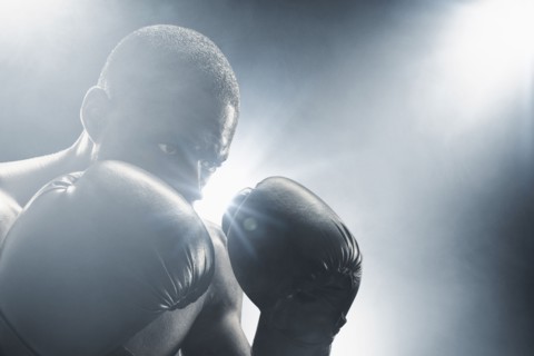 African American boxer with gloves raised