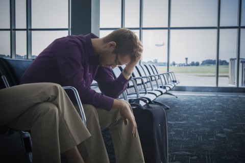 Frustrated Caucasian man sitting airport
