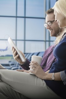 Caucasian couple using digital tablet in airport