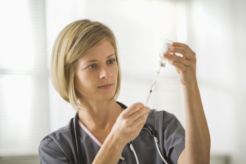 Caucasian nurse filling syringe