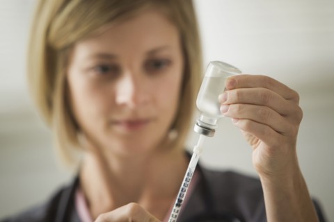 Caucasian nurse filling syringe
