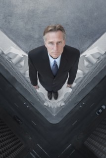 Caucasian businessman on skyscraper ledge