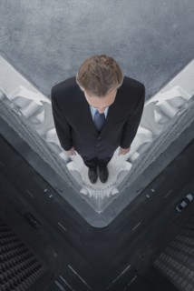Caucasian businessman on skyscraper ledge