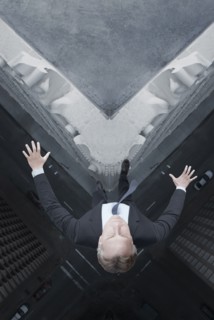 Caucasian businessman jumping off skyscraper