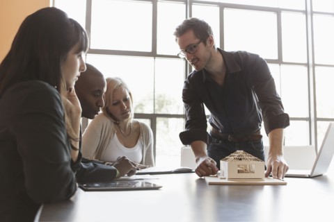 Business people examining model in meeting