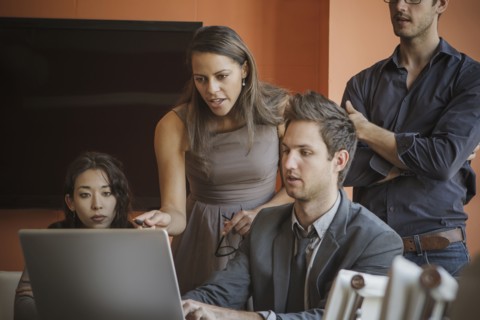 Businesspeople using laptop in meeting