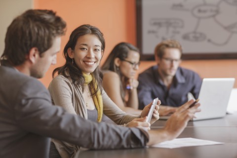 Mixed race businesswoman smiling in meeting