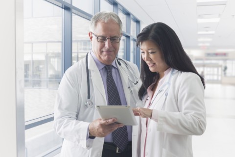 Doctors using tablet computer in hospital