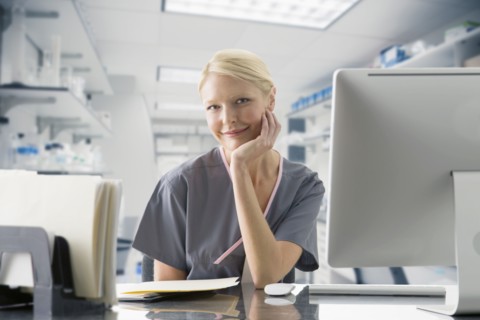 Caucasian nurse working at computer in hospital