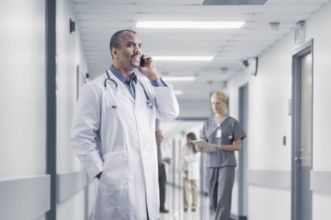 Mixed race doctor talking on cell phone in hospital