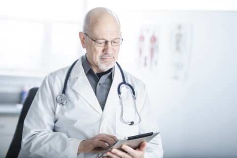 Caucasian doctor using tablet computer in office