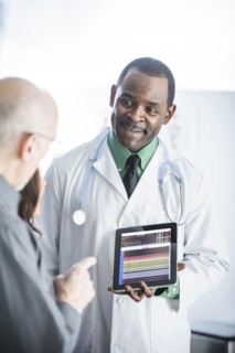 Doctor showing tablet computer to patients