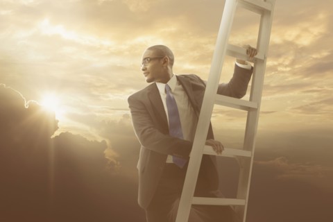 African American businessman climbing ladder