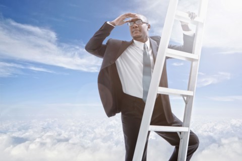 African American businessman climbing ladder