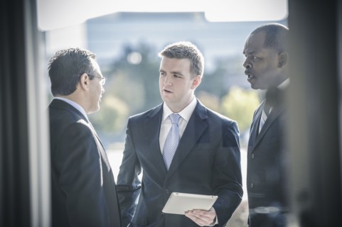 Businessmen using digital tablet outside office