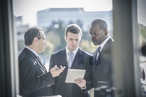 Businessmen using digital tablet outside office
