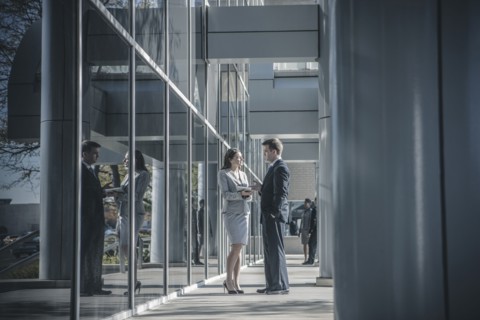 Business people talking outside office building