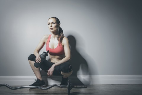 Caucasian woman in sportswear resting with water bottle