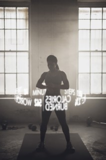 Virtual words circling Black athlete checking fitness tracker
