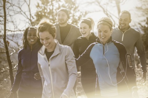 Laughing friends walking on forest path