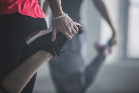 Athletes stretching legs in gym