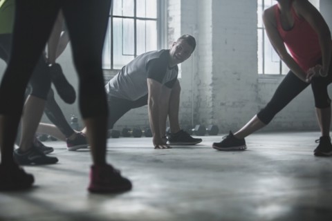 Athletes stretching legs in gym