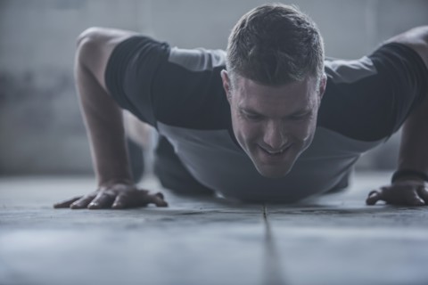 Caucasian athlete doing push-ups on floor