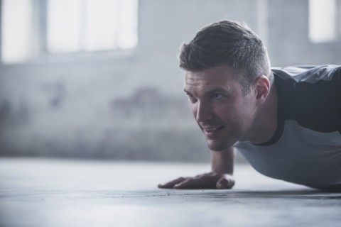 Caucasian athlete doing push-ups on floor