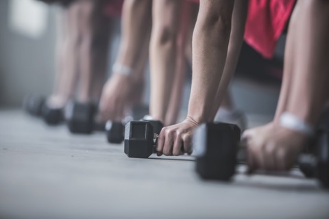 Athletes doing push-ups and lifting weights on floor
