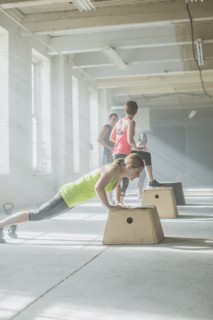 Athlete doing push-ups on platform in gym
