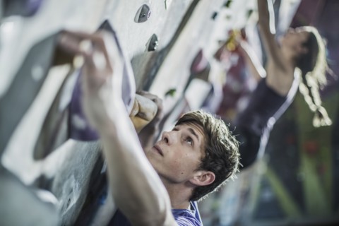 Athletes climbing rock wall in gym
