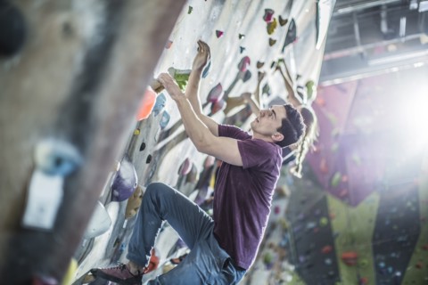 Athletes climbing rock wall in gym