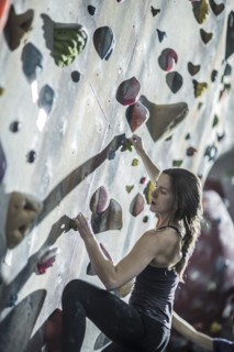 Athlete climbing rock wall in gym