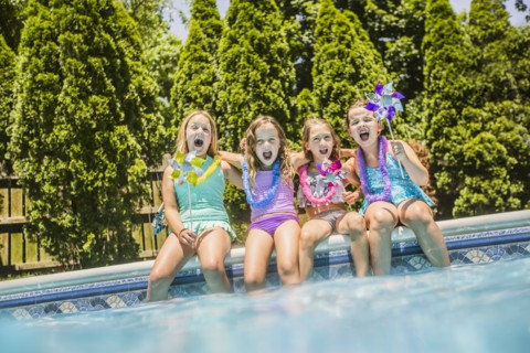 Caucasian girls cheering at swimming pool