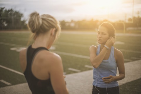 Athletes listening to mp3 players on sports field