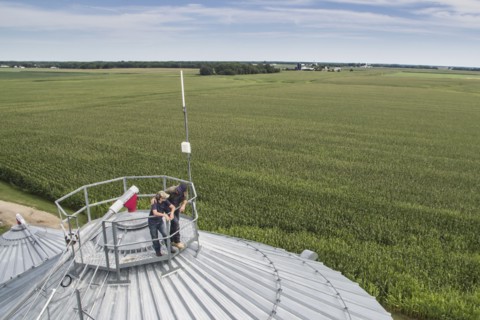 Caucasian farmer and son admiring farm from silo
