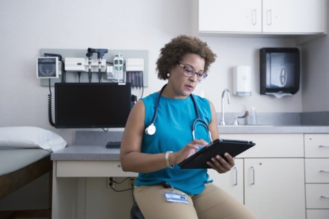 African American doctor using digital tablet