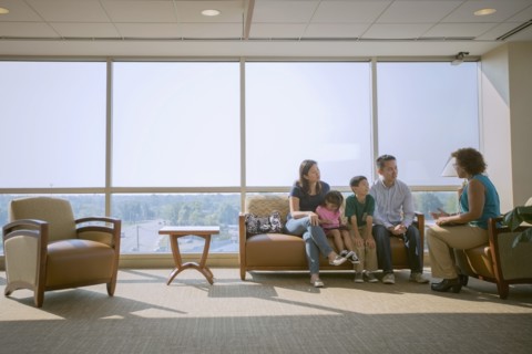 Doctor talking to patients in waiting room