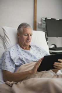 Caucasian man using digital tablet in hospital room