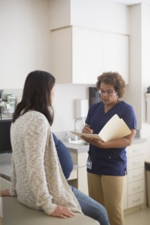 Nurse talking to pregnant patient in hospital room