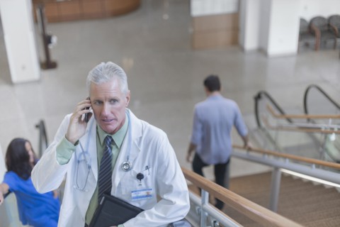 Doctor talking on cell phone on steps