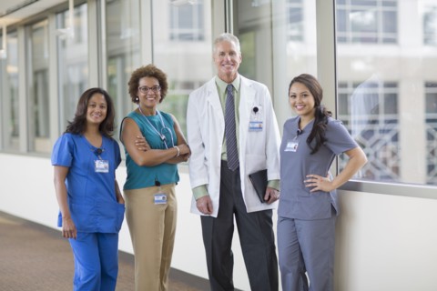 Doctor and nurses smiling in hospital hallway