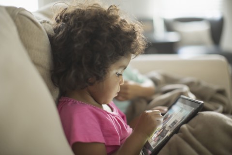 Girl using digital tablet on sofa