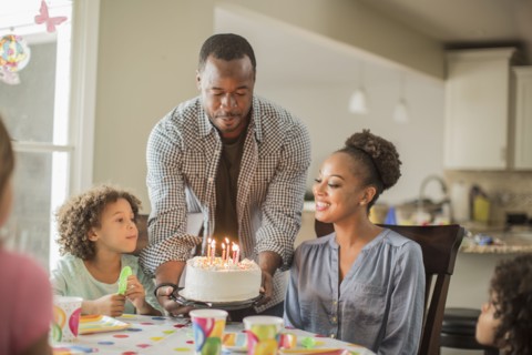 Girl admiring birthday cake at party